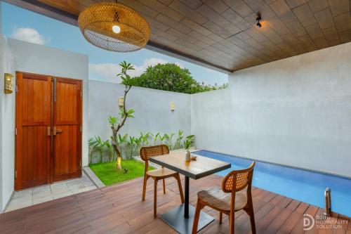 a dining room with a wooden table and chairs at ME Villa Pererenan in Canggu