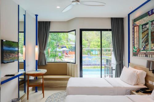 a hotel room with two beds and a balcony at Holiday Style Ao Nang Beach Resort, Krabi in Ao Nang Beach