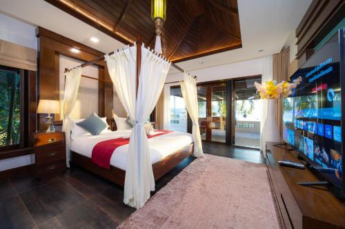 a bedroom with a bed with a canopy at D Villa Phuket - Luxury 6 Bedroom Private Pool Villa in Cape Panwa in Phuket