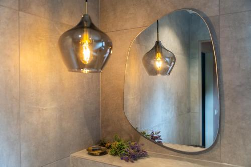 a bathroom with two lights and a mirror at Schoapdiek Huuskes in Overdinkel