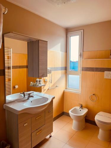 a bathroom with a sink and a toilet and a window at Locanda Munerato in Padova