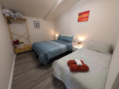 a bedroom with two beds with a stuffed animal on it at The Flat on Muddy in Moonta