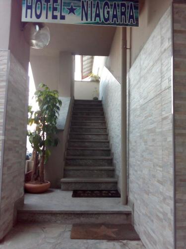 a staircase leading up to a building with a sign at Hotel Niagara in Caselle Torinese