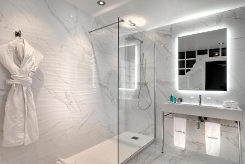a white bathroom with a shower and a sink at CAZAUDEHORE Hôtel Restaurant Gastronomique Terrasse et Jardins in Saint-Germain-en-Laye