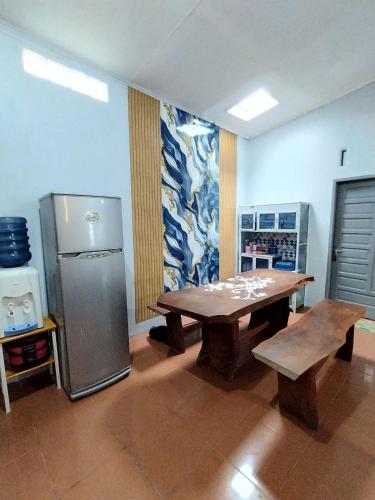 a kitchen with a wooden table and a refrigerator at Villa Bukit Asri Berastagi 08 in Berastagi