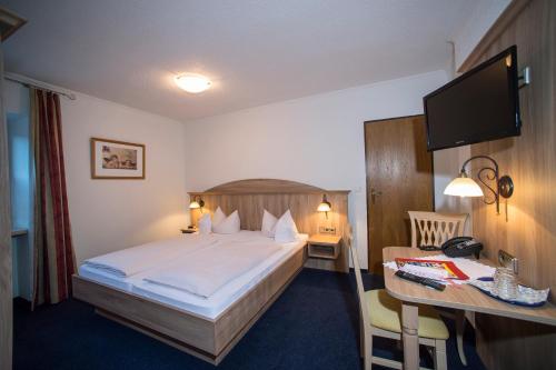 a hotel room with a bed and a desk at Aktivhotel & Gasthof Schmelz Ihr familienfreundliches Urlaubs Hotel mit Wellness Hallenbad, Alpensauna neu ab Februar 2026 Chiemgau Karte in Inzell