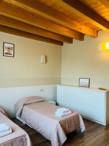 two beds in a room with wooden ceilings at Locanda Munerato in Padova