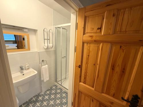 a bathroom with a sink and a toilet and a shower at The Colony Townhouse Dingle in Dingle