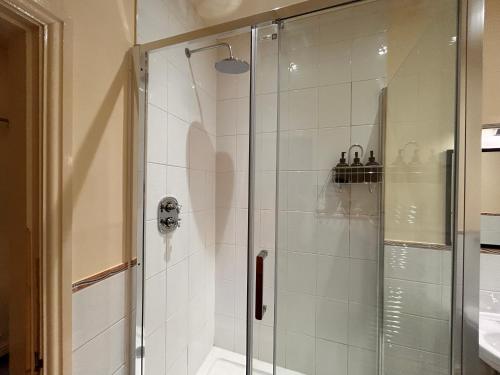 a shower with a glass door in a bathroom at Deandale Stays in Handforth