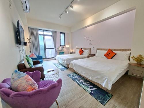 a hotel room with two beds and two chairs at Youngnn Hostel in Lukang
