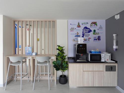 a kitchen with a counter and a table and stools at HOP INN Chonburi Bowin in Ban Phan Sadet Nai