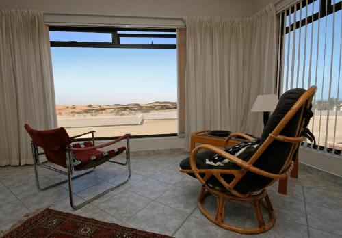 a living room with two chairs and a large window at Chala-Kigi Apartments in Swakopmund