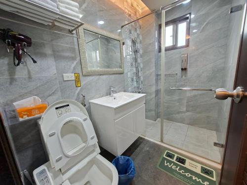 a bathroom with a shower and a toilet and a sink at Youngnn Hostel in Lukang