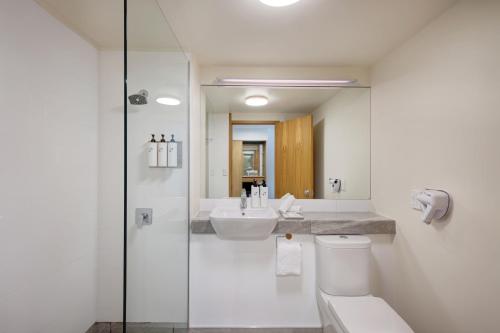 a bathroom with a sink and a toilet and a mirror at Swiss-Belresort Coronet Peak in Queenstown
