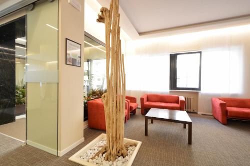 a lobby with a tree and red chairs at Best Western Hotel Crimea in Turin