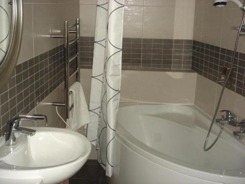 a bathroom with a tub and a toilet and a sink at To Kastri in Kalopanayiotis