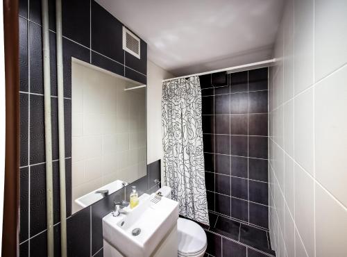 y baño con aseo, lavabo y espejo. en Apartamenty Spodek, en Katowice