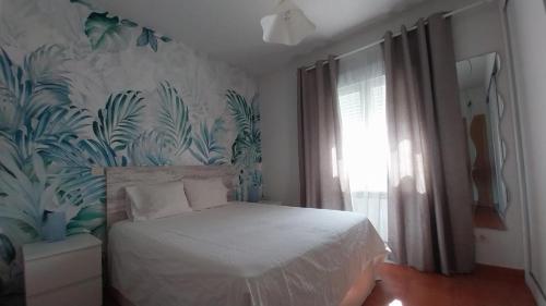 a bedroom with a bed with a tropical wallpaper at El Encanto de Valladolid in Aldeamayor de San Martín