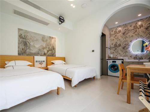 two beds in a white room with a table and a mirror at LeD Courtyard Homest ay乐东小院民宿 in Beijing