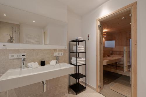 a bathroom with a sink and a bathroom with a shower at Pure Tinnum in Sylt
