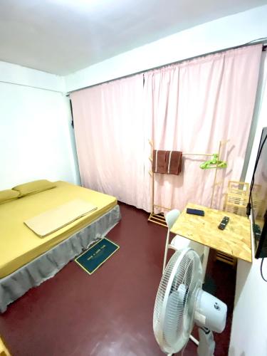 a room with a bed and a fan and a table at J&T House And Friends in Ban Khlong Nam Ron