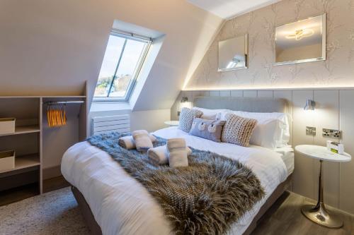a bedroom with a large bed with a furry blanket at Arran Shores Luxury Shorefront Apartment 14 in Lamlash