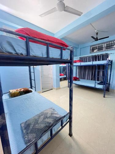 two bunk beds in a room with a ceiling fan at Patkai Backpackers Hostel in Guwahati