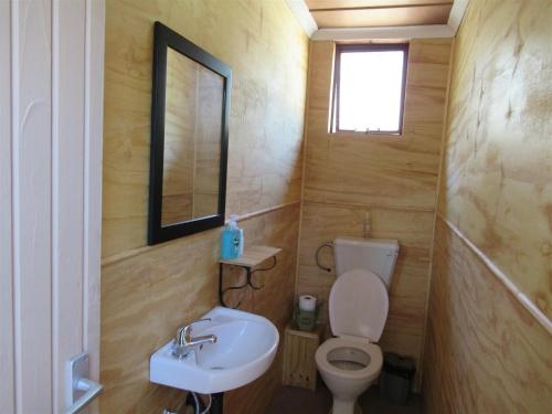 a small bathroom with a toilet and a sink at Honey Nest Camp in Derby