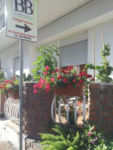 a sign in front of a building with flower boxes at B&b Irma in Olivarella