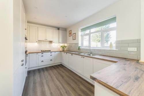 a kitchen with white cabinets and a large window at WJShortlets - 48HarwellRd in Abingdon