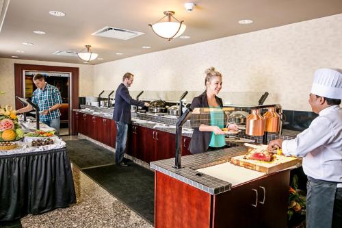 a group of people in a kitchen preparing food at Chateau Nova Yellowhead in Edmonton