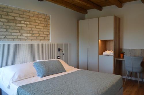 a bedroom with a bed and a brick wall at B&B Casa Anì in Pordenone