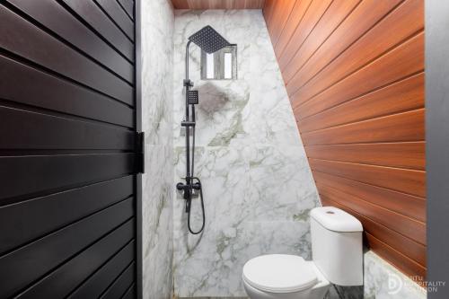 a bathroom with a shower with a toilet in it at Dieng Ceria Resort in Diyeng