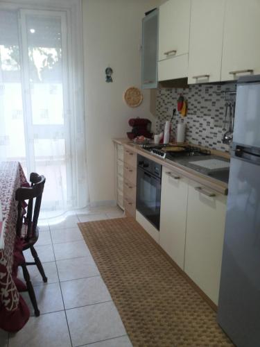a kitchen with white cabinets and a stove top oven at B&b Irma in Olivarella