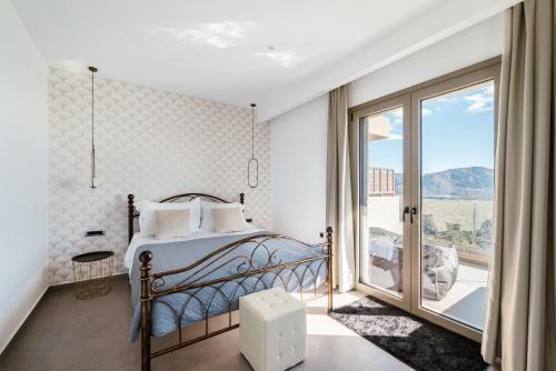 a bedroom with a bed and a large window at Thea Villas in Makry Gialos