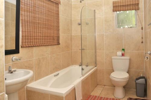 African Aquila Guest Lodge في بورت اليزابيث: حمام مع حوض ومرحاض ومغسلة