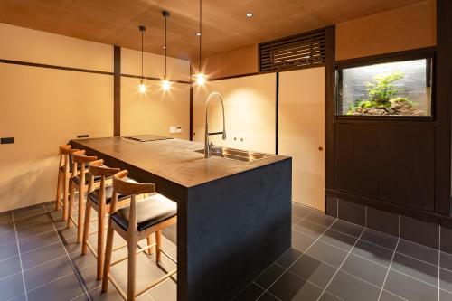 a kitchen with a large island with a sink and chairs at Guesthouse Hana - Harmony Villa in Kyoto