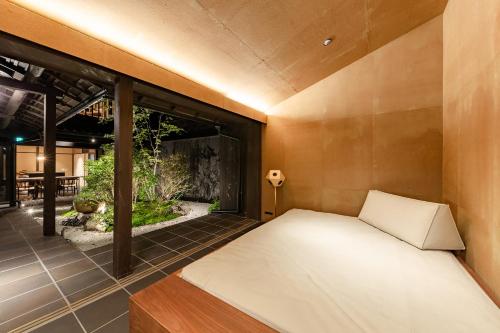 a bedroom with a bed and a large window at Guesthouse Hana - Harmony Villa in Kyoto