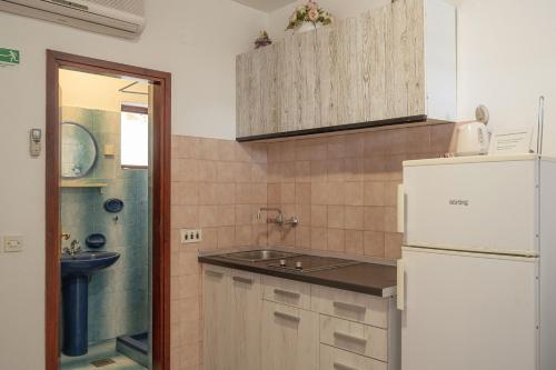 a kitchen with a white refrigerator and a sink at Apartments Lea in Prizba