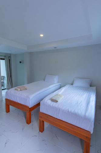 two beds sitting next to each other in a room at Lamtam Maesa Resort ลำธารแม่สา รีสอร์ท in Mae Rim