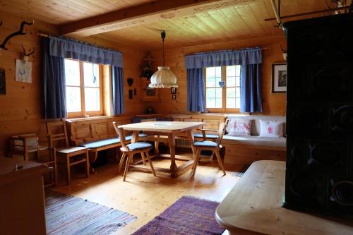 a dining room with a table and chairs in a cabin at Ferienhaus Heutal in Unken