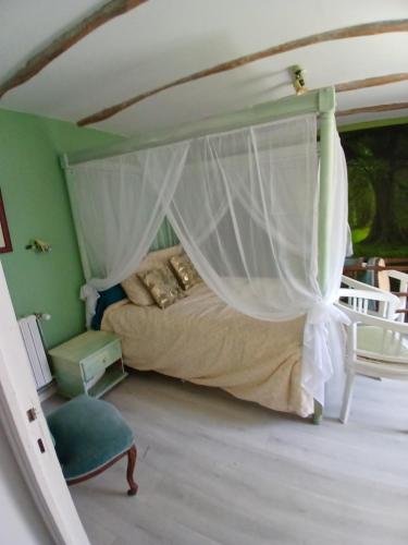 a bedroom with a bed with a canopy at au calme a 2pas des côtes du finistere sud in Bannalec