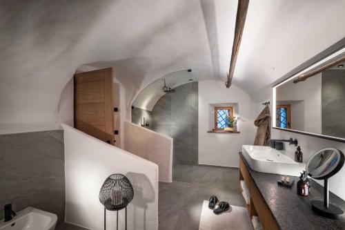a white bathroom with a sink and a mirror at Sorafurcia Lodge in Sorafurcia