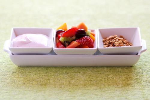 Greenleaf Guest Lodge في بلومفونتين: وعاء من الفاكهة والزبادي والمكسرات على الطاولة