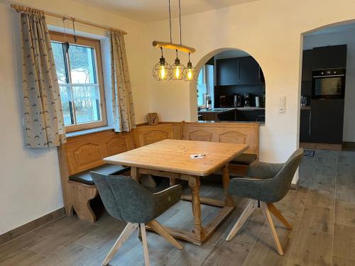 a kitchen with a wooden table and chairs at Woidzeit by Sigl in Kollnburg