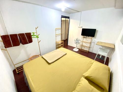 a bedroom with a yellow bed and a tv at J&T House And Friends in Samutprakarn