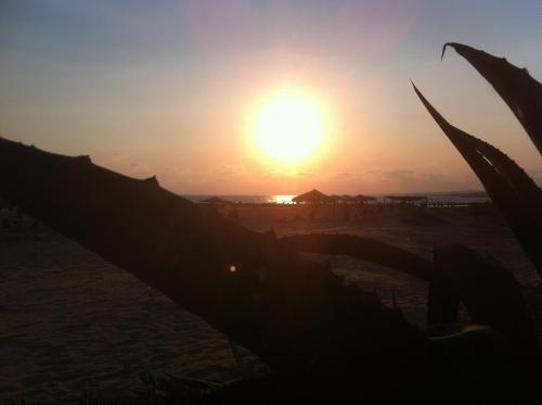 a sunset on the beach with the sun in the sky at Villa Unica Terrazzo Sul Mare in Donnalucata