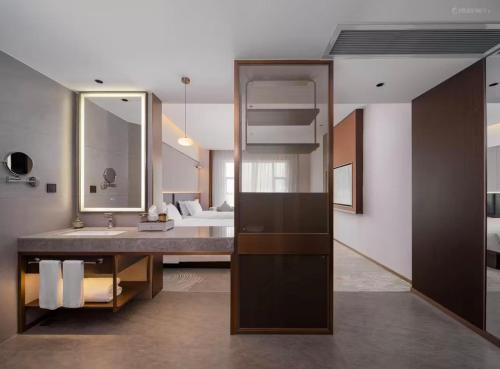 a bathroom with a sink and a large mirror at SINOKAI International Hotel in Dongguan