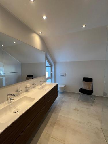 a bathroom with two sinks and a large mirror at Haus Lurnfeld in Baldramsdorf