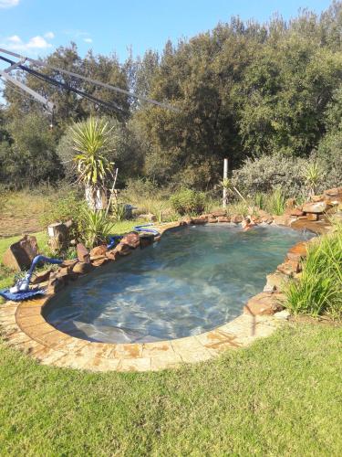 a small pool with a rock border in a yard at Honey Nest Camp in Derby